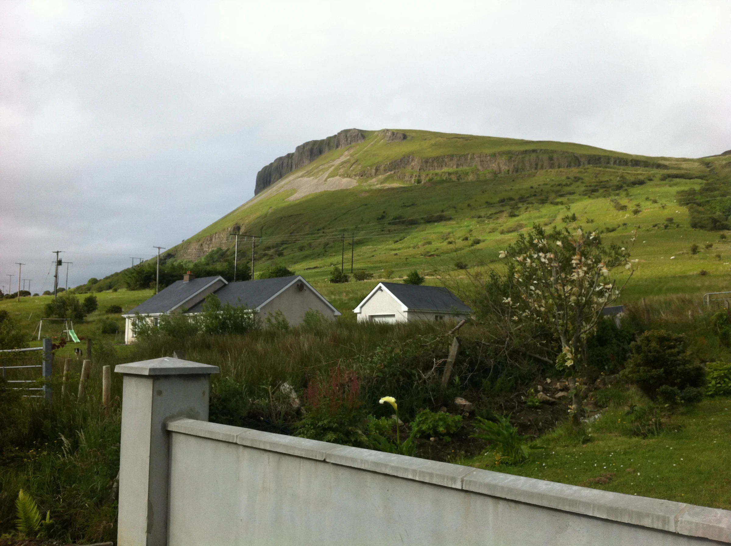 Houses and green fields beneath the steep hillside at Glenade, County Leitrim, photographed in 2013