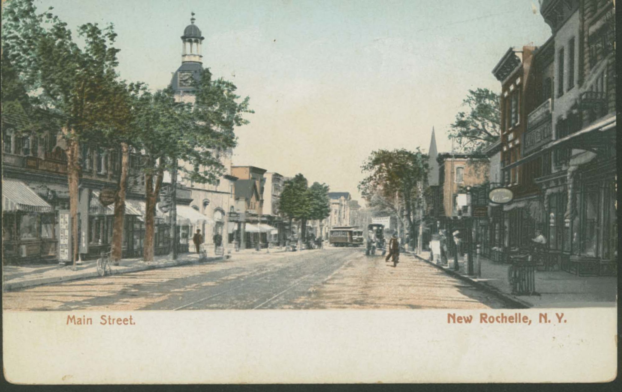 New Rochelle Main Street around 1905, with shopfronts, trolley tracks, a streetcar and people in the road